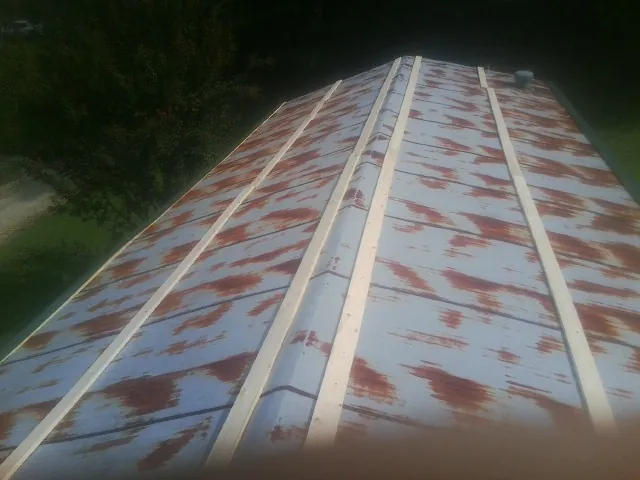 Rusted metal roof panels with new wood purlins before replacement — Storm Damage Roof Repair in Owingsville by Roofing Brothers