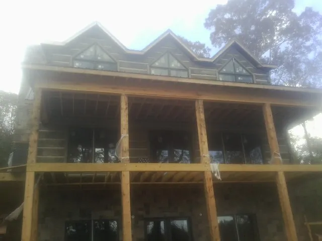 Dormers and porch framing on a large log home under construction — Roof Coating work by our crew in Owingsville