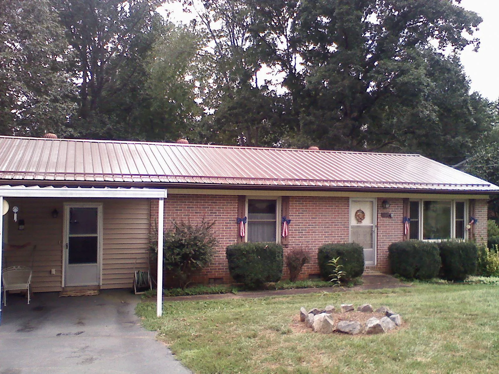 Bronze metal roof and carport on a brick ranch home — Roof Repair work by our crew in Owingsville